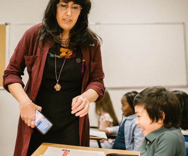 Instructor gently assisting a person with their posture in a class.